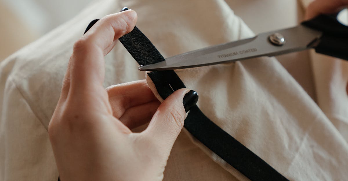 A seamstress cuts fabric around a mannequin in a fashion workshop, showcasing the art of tailoring.