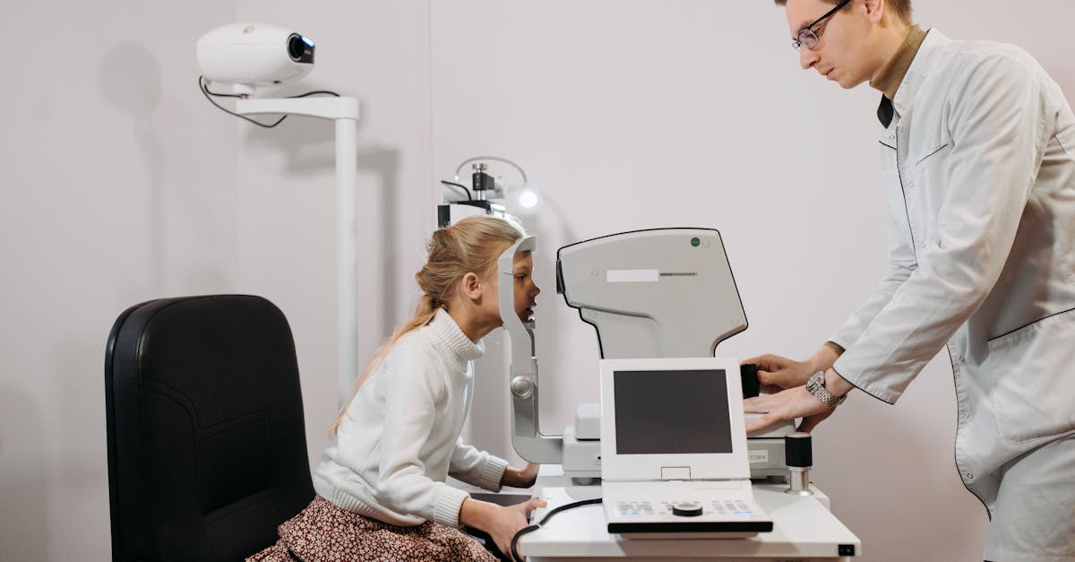 A young girl receives an eye exam from an optician in a clinical setting, focused on vision health.